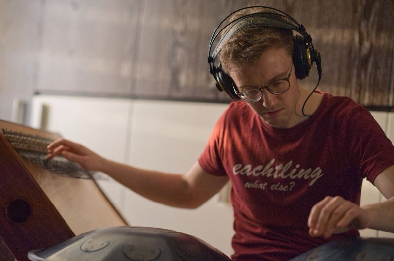 Leonhard Waltersdorfer spielt mit Kopfhörern Mbira und Handpan im Studio.