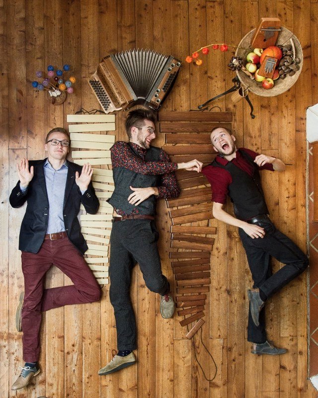 Press photo Quetsch ’n’ Vibes: Jonny Kölbl, Leonhard Waltersdorfer and Hannes Schöggl lying on a wooden floor among their instruments.