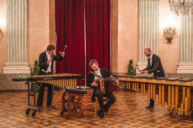 Das Trio im Frack spielt im Festsaal des Palais Auersperg: Vibraphon, Steirische Harmonika und Marimba.